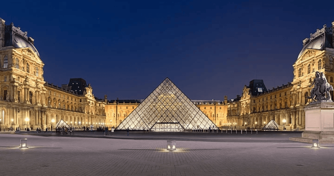 Louvre Museum pyramid in the Cour Napoléon courtyard at dusk