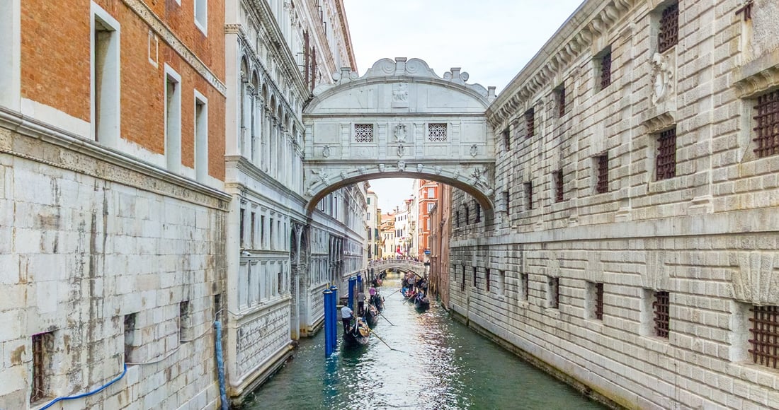 The Bridge of Sighs arching over a narrow canal between the Doge's Palace and the old prisons in Venice, with gondolas below