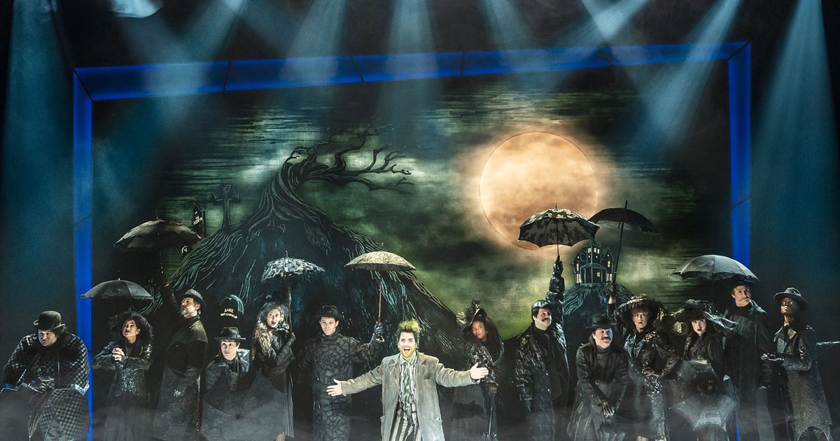 The company of Beetlejuice The Musical on stage under a full moon in the West End production