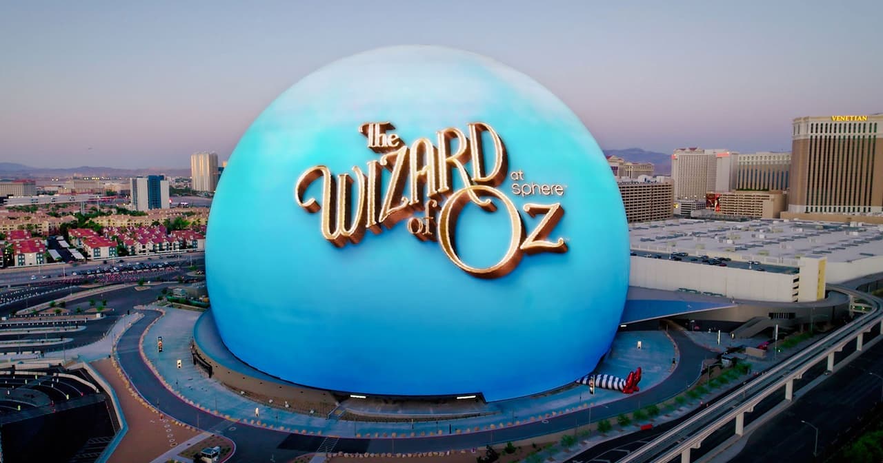 The Las Vegas Sphere lit up blue with The Wizard of Oz artwork above the Strip skyline at dusk