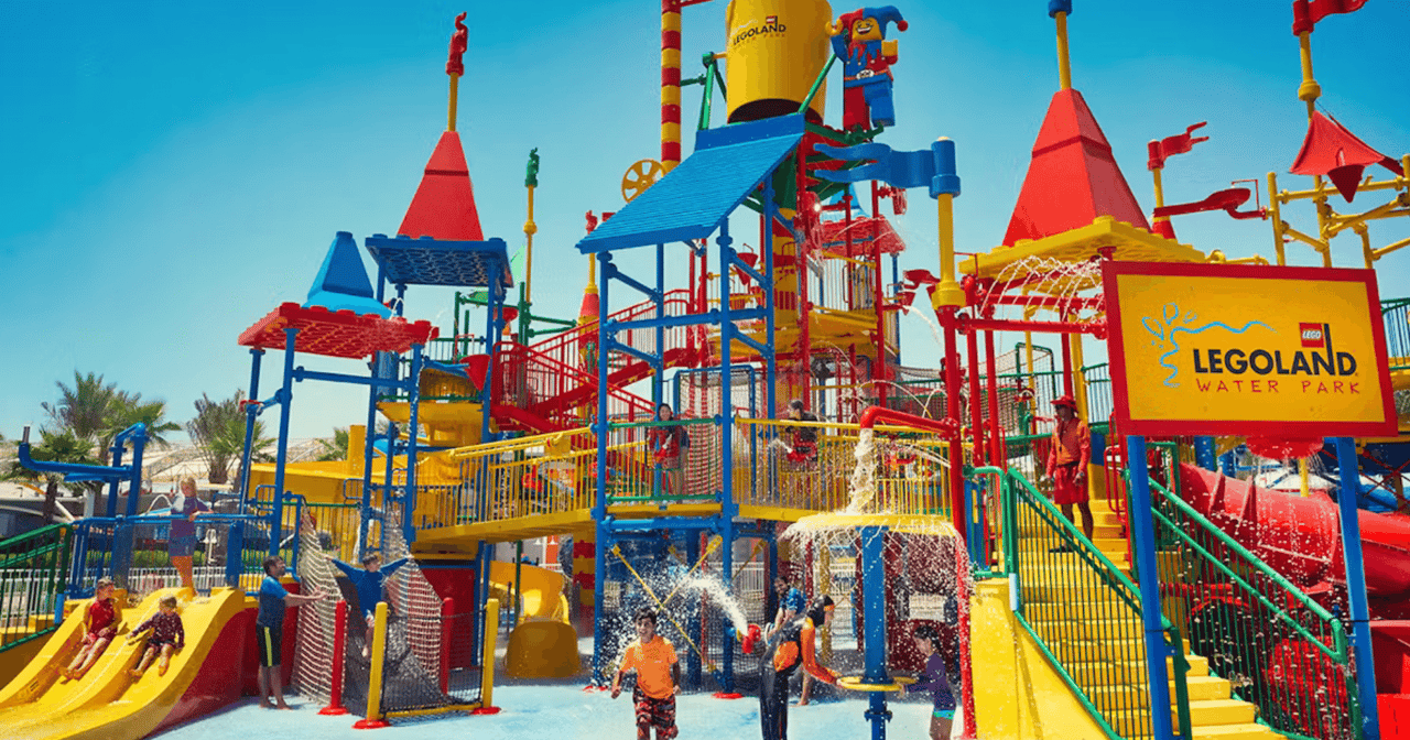 Colourful play structure and water slides with children splashing at LEGOLAND Water Park Dubai