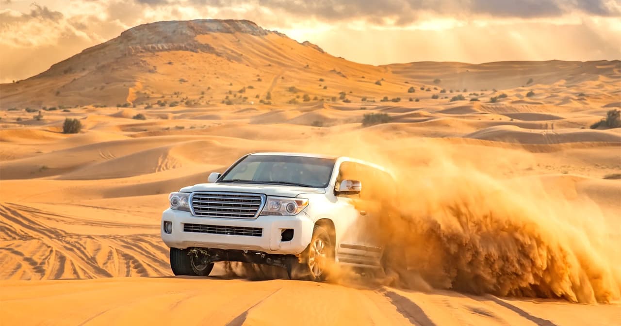 A 4x4 vehicle throws sand as it explores the desert dunes in Dubai.