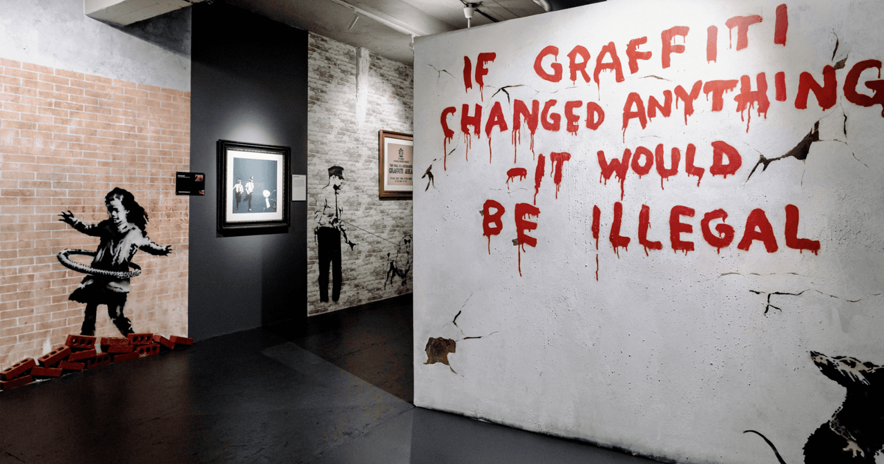 Banksy Museum gallery in New York with the If Graffiti Changed Anything mural and hula-hoop girl