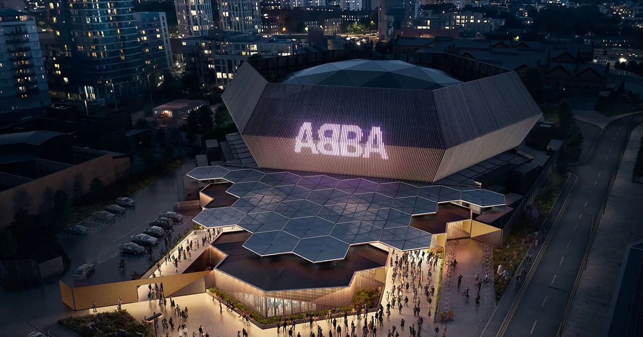 ABBA Arena lit up at night in London with the ABBA logo glowing on the hexagonal dome