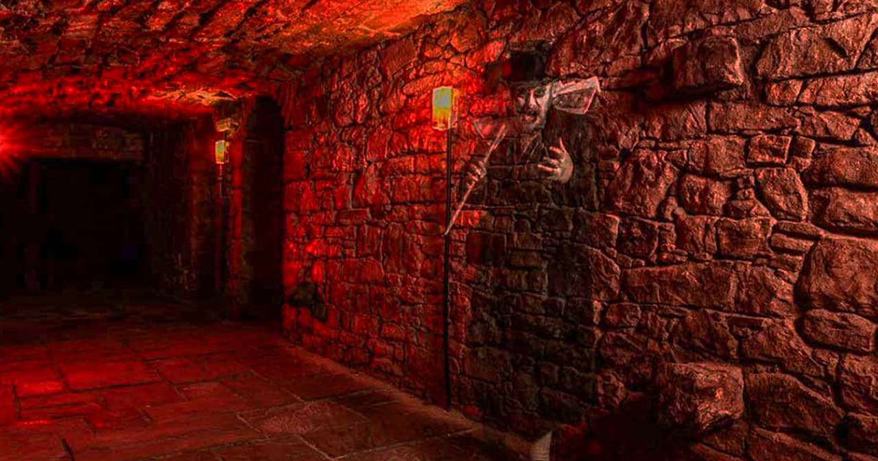 Costumed figure in a red-lit underground stone vault on an Edinburgh ghost tour
