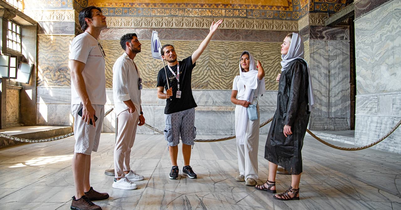 Tour guide pointing out gold mosaics to visitors inside the Hagia Sophia in Istanbul