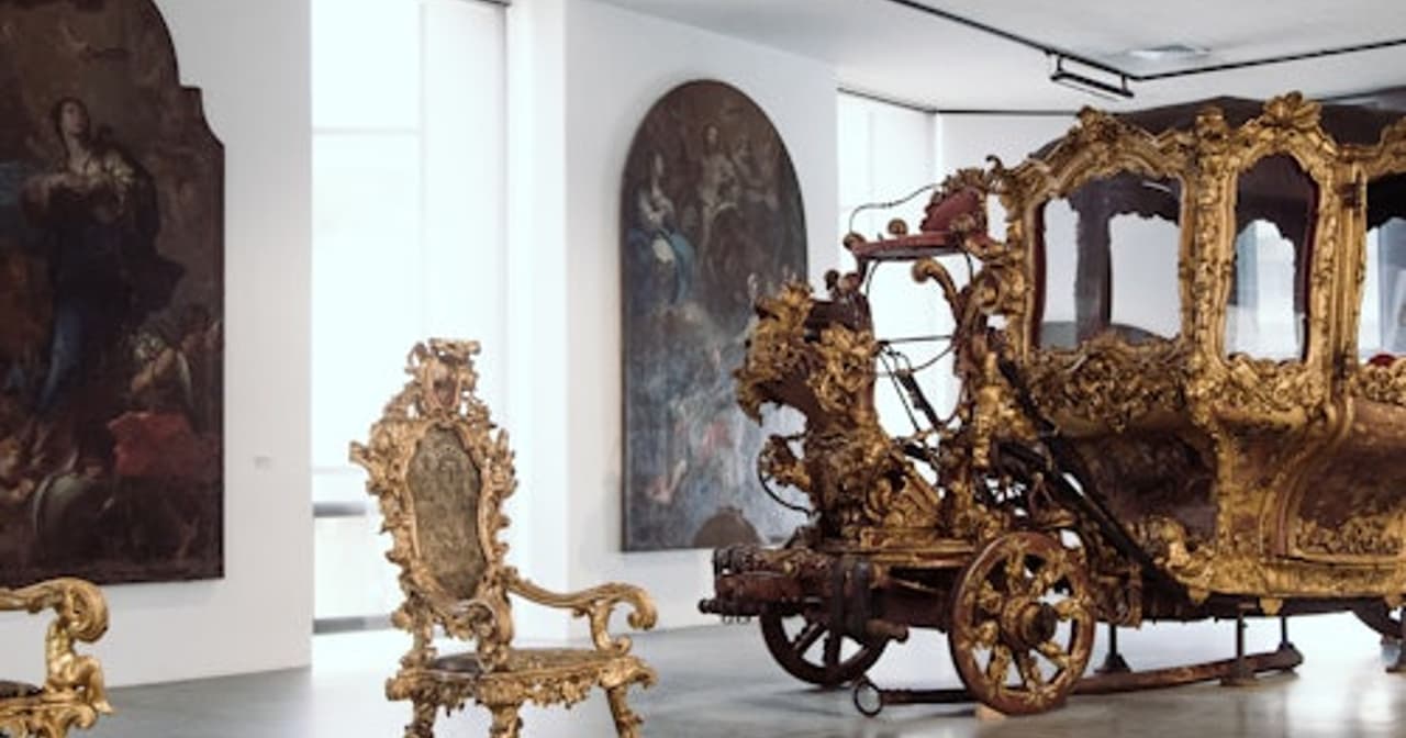 Sicilian museum gallery in Messina with a gilded baroque carriage and ornate golden chairs
