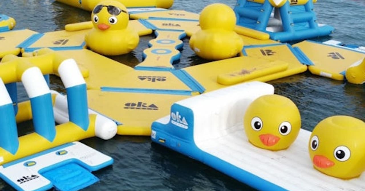 Yellow and blue inflatable water park with giant rubber ducks on the sea at Salou