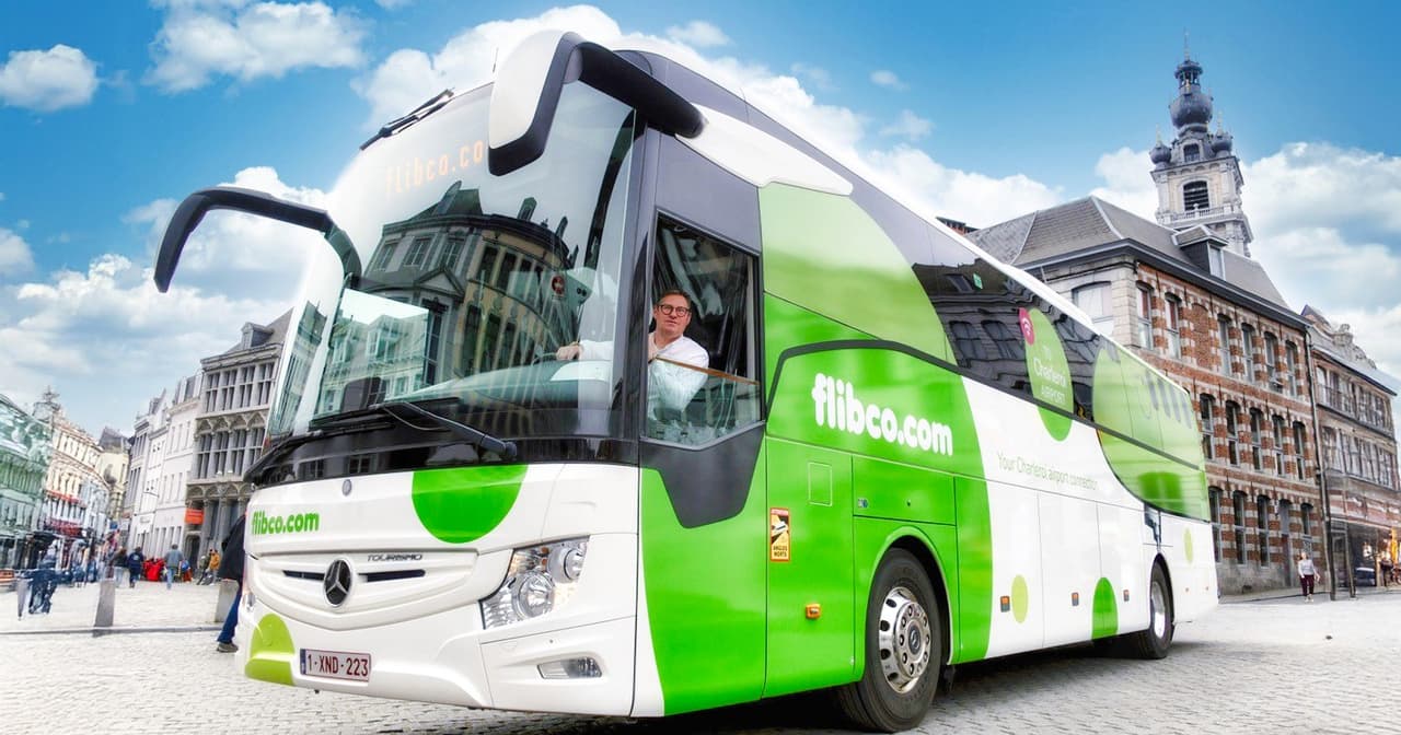 Flibco airport transfer bus in a European city square.