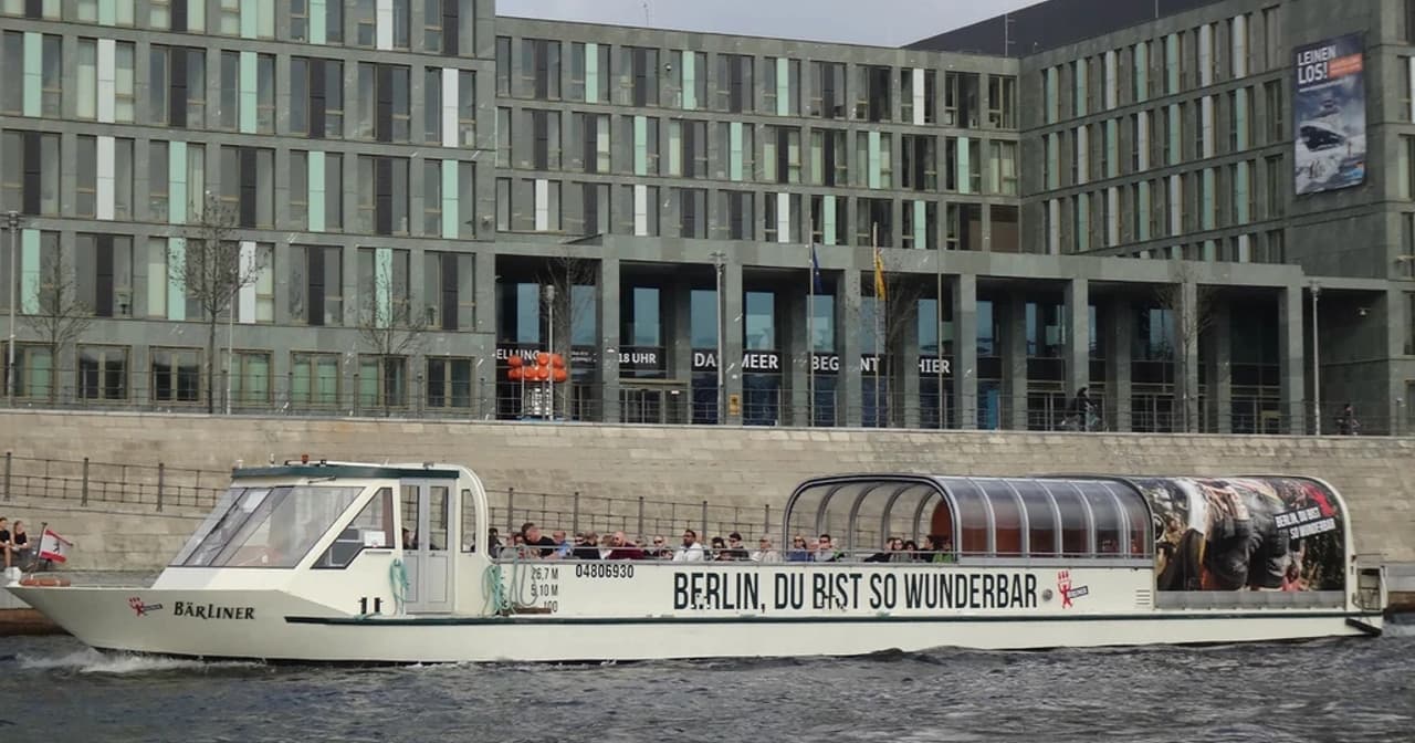 Statek wycieczkowy na rzece Spree w Berlinie z nowoczesnymi szklanymi budynkami na tle