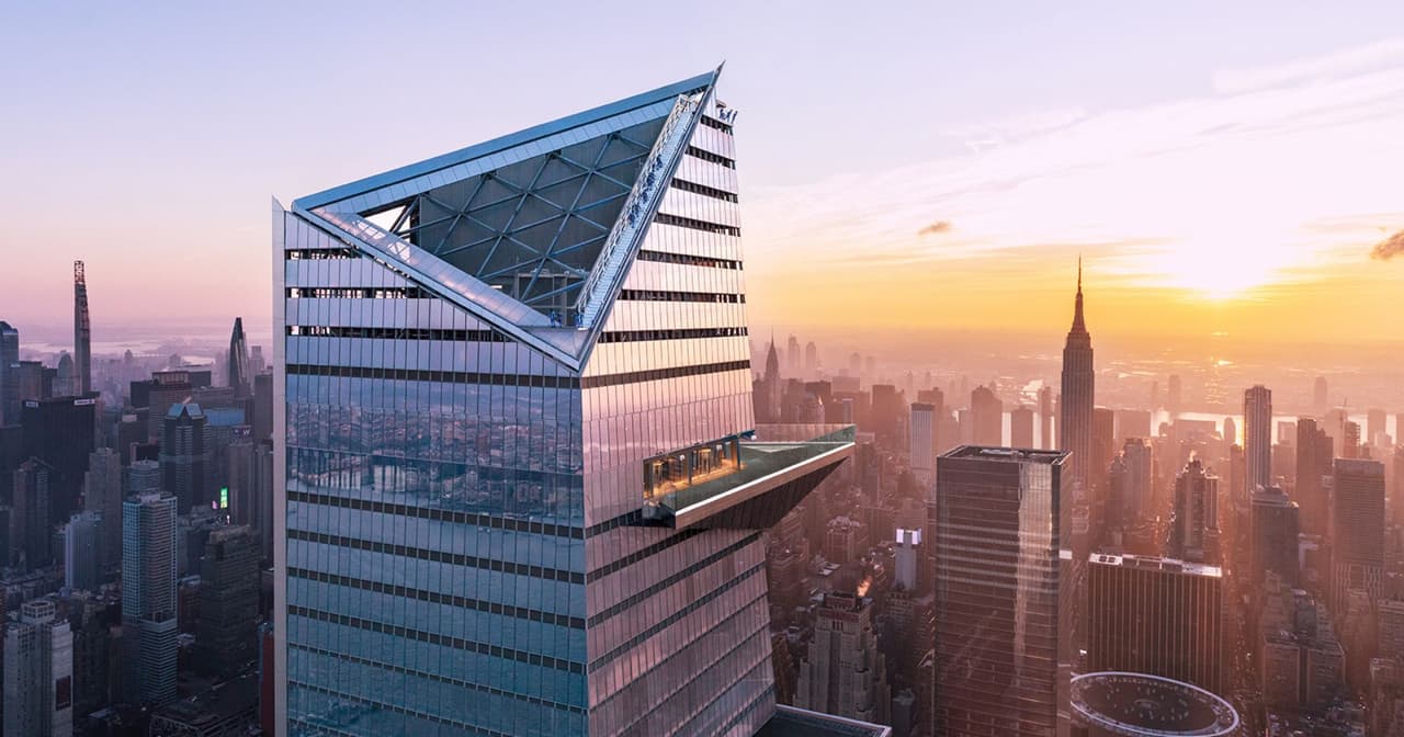 Edge observation deck glass platform jutting over the New York City skyline at sunset