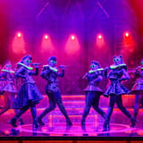 The six queens of Six the Musical in silver costumes, singing in formation at the Vaudeville Theatre