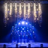 The company of Now You See Me Live on stage under pyrotechnics at the London Coliseum