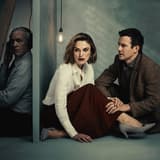 Stephen Dillane listening through headphones on one side of a wall, with Keira Knightley and Luke Thompson on the other, in The Lives of Others