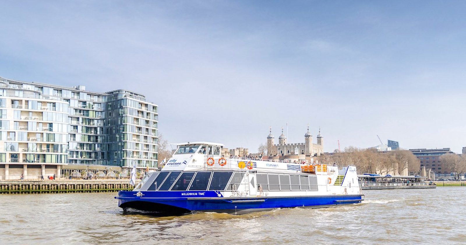 Cruise boat on the Thames River with the Tower of London in the background.