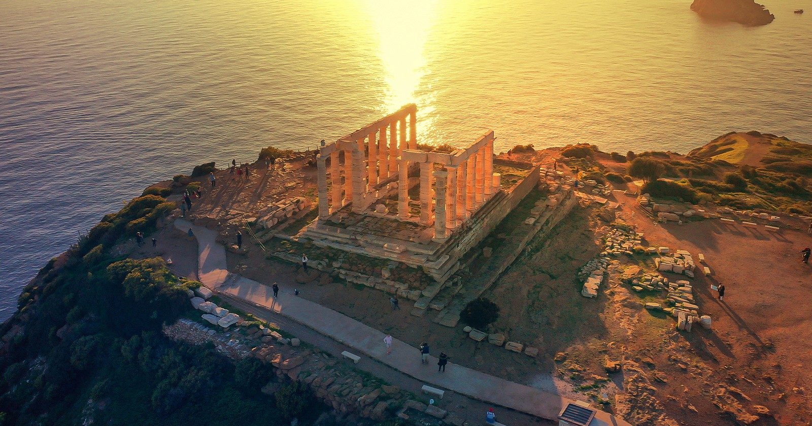 Sunset over the sea with an aerial view of the Temple of Poseidon
