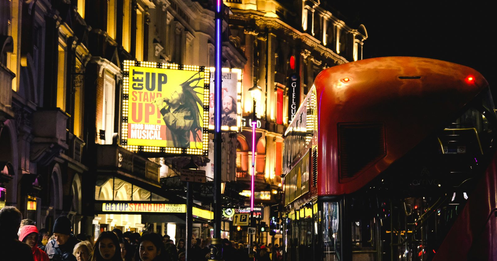 a red double decker bus driving down a street