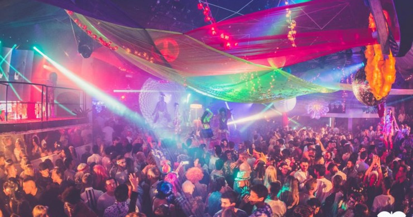 Crowd dancing under colourful lights at a Pacha club night in Ibiza