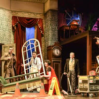 Cast members on stage during a chaotic scene from "The Play That Goes Wrong