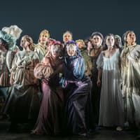 Cast of "Into The Woods" in costume on stage during a theatrical performance