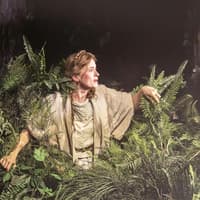 Performer in forest setting during "Into The Woods" production