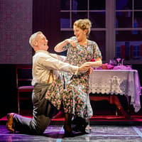 Couple dancing in a scene from Sinatra The Musical, Westend, with a dining table in the background