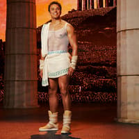 Man in ancient Greek attire stands between columns, representing Disney's Hercules