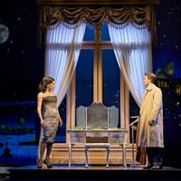 Actors on stage in Sinatra The Musical, Westend, with a night cityscape backdrop