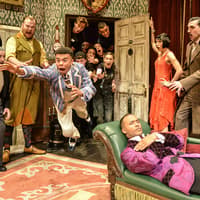 Actors performing a chaotic scene in "The Play That Goes Wrong" on stage