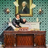 Stage scene from Oh, Mary Westend show with actor at desk, papers flying