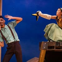 Actors performing Stick Man on West End stage with puppet interaction