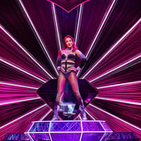 Performer on stage at Moulin Rouge! The Musical, West End, with vibrant pink lighting