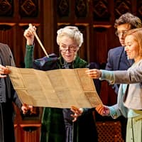 Actors on stage examining a map in "Harry Potter and the Cursed Child" play