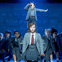 Children performing a scene from Matilda The Musical on stage