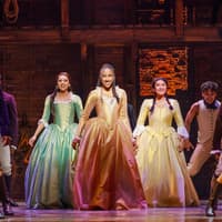 Cast performing on stage in a scene from the musical Hamilton