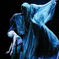 Stage scene from "Harry Potter and the Cursed Child" with a ghostly figure looming over a character