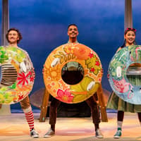 Performers with colorful float rings in Stick Man stage show, West End