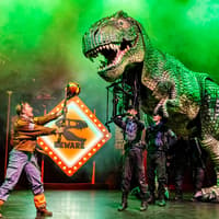 Stage performance of Dinosaur World Live with a large dinosaur puppet, Westend