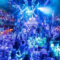 Guests enjoying Mamma Mia! The Party performance with vibrant lights and festive atmosphere