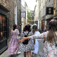 Tour group in period costumes with headphones walking through Bath's historic streets — Bridgerton: 1.5 Hour Guided Tour of Filming Locations in Bath with Music