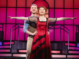 Stage performance of Titanique Westend with actors in embrace on a vibrant set