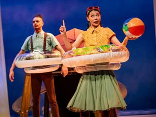 Stage performance of Stick Man in Westend with actors holding inflatable rings and a beach ball