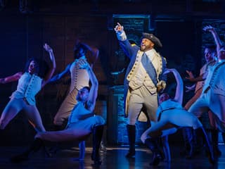 Cast performing a scene from the Hamilton musical on stage