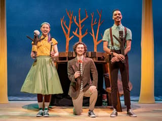 Performers on stage during Stick Man show, West End, with tree props in background