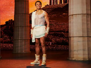Man in ancient Greek attire stands between columns, representing Disney's Hercules