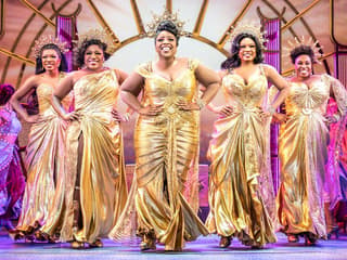 Performers in golden costumes on stage during Disney's Hercules musical