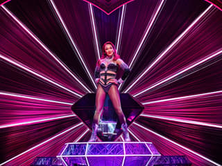 Performer on stage at Moulin Rouge! The Musical, West End, with vibrant pink lighting