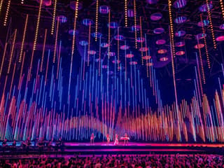 ABBA Voyage concert stage with colorful light display and audience
