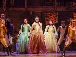 Cast performing on stage in a scene from the musical Hamilton