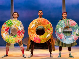 Performers with colorful float rings in Stick Man stage show, West End